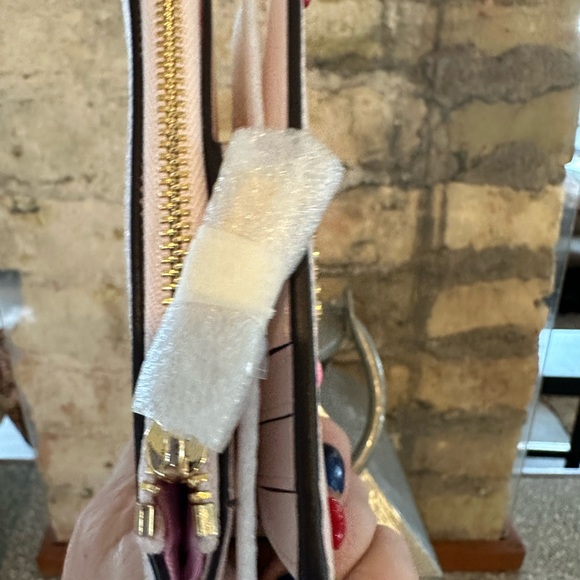 Kate Spade wallet is a light pink wallet adorned with small heart-shaped studs - Picture 10 of 16